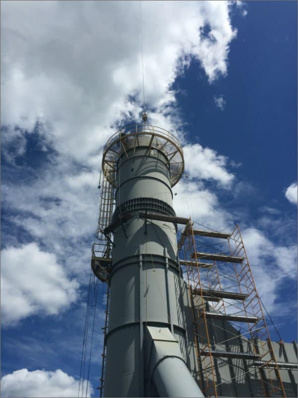 industrial exhaust stack with a blue sky and clouds