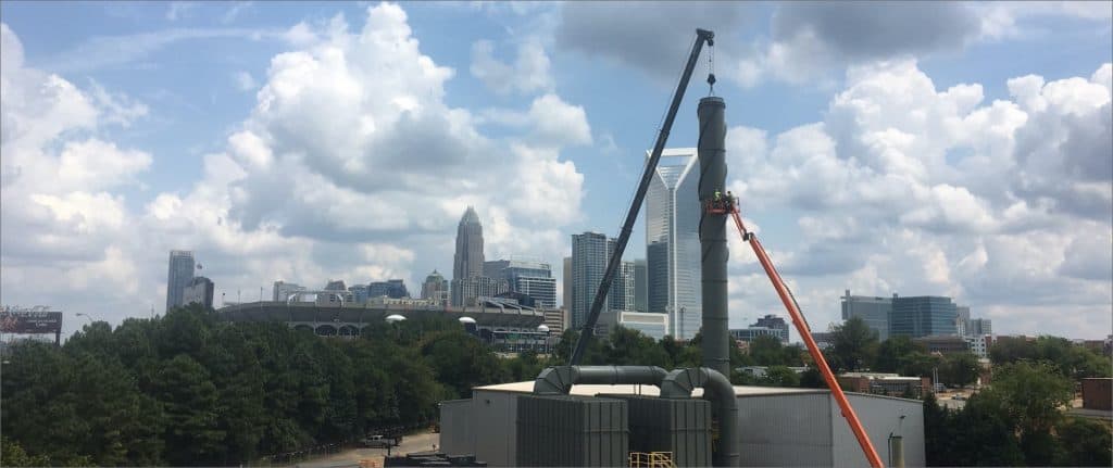 Installing industrial stack with Charlotte. NC, in background